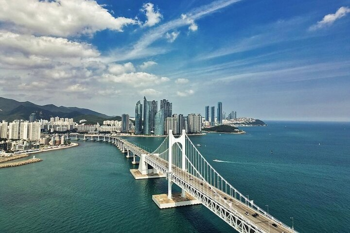 Experience the stunning views of Gwangan Bridge and Busan's skyline where modern architecture meets the sparkling sea creating an unforgettable backdrop for your journey through this coastal city.